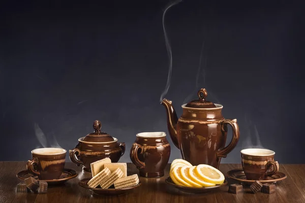 Heißer Kaffee in Tassen und Dessert auf einem Tisch — Stockfoto