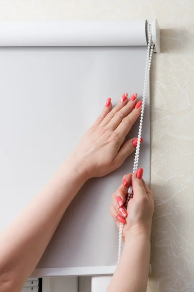 Las manos femeninas con manicura cierran persianas y persianas en la ventana —  Fotos de Stock