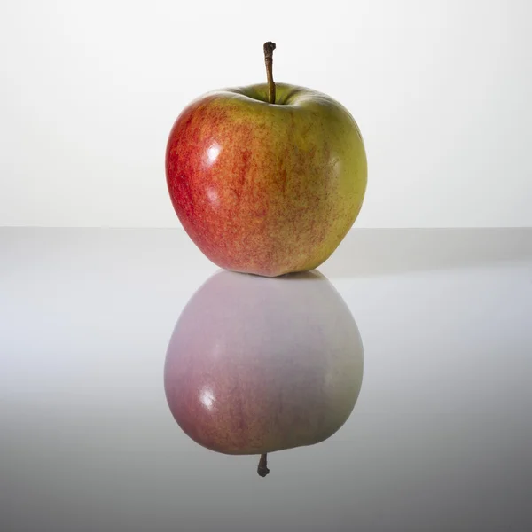 Hermosa manzana en una superficie con reflejo — Foto de Stock