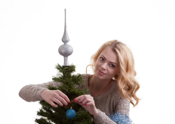 Mooi meisje siert een kerstboom — Stockfoto