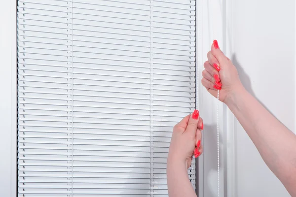 Las manos femeninas cierran persianas en la ventana —  Fotos de Stock