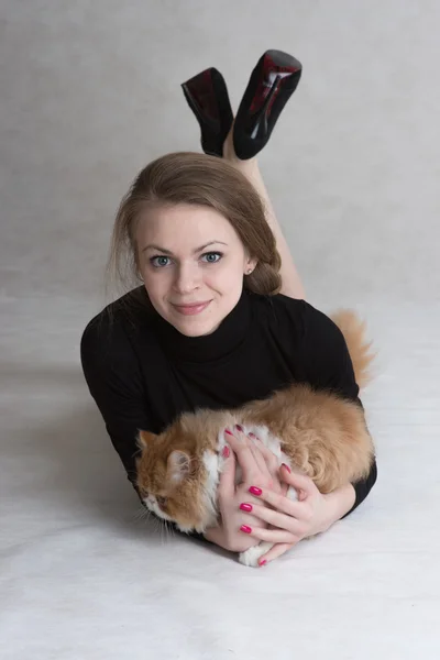 Very nice girl holds a red kitten — Stock fotografie