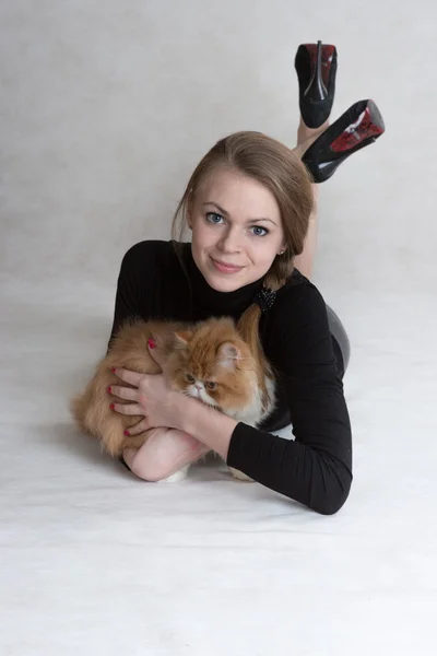 Very nice girl holds a red kitten — Stock fotografie