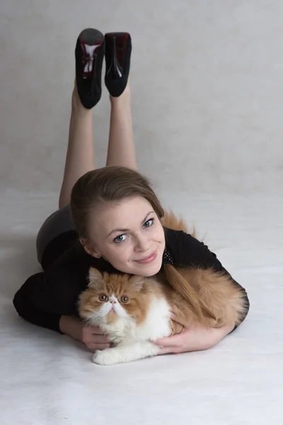 Very nice girl holds a red kitten — Stock fotografie