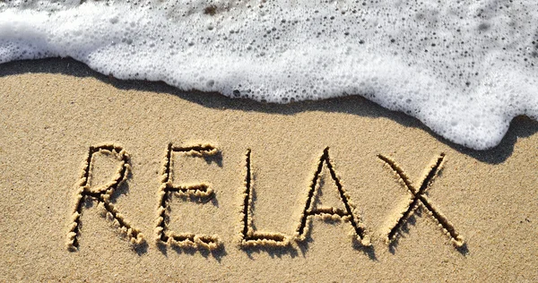 Meeresbrandung und das Wort Relax im Sand — Stockfoto