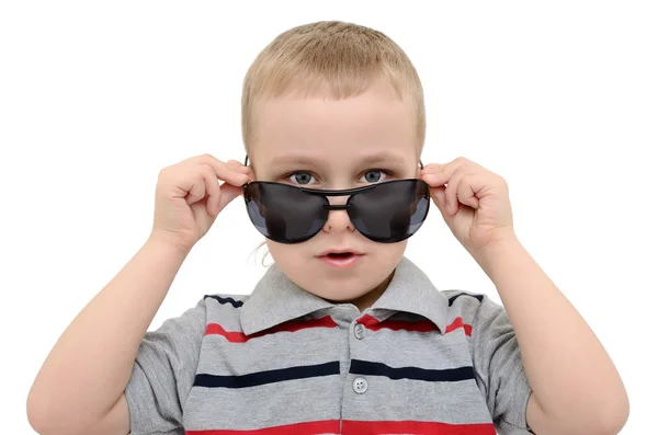 Niño mirando por encima de sus gafas sobre un fondo blanco — Foto de Stock