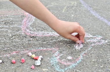Çocuk el kaldırımda tebeşir ile çizer. Yaratıcı eğlence
