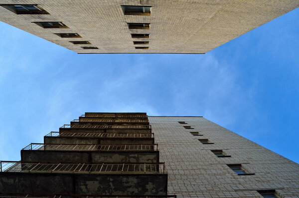 Old Soviet, multi-storey building against a blue sky, bottom view