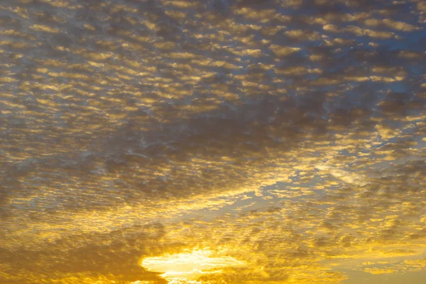 Zlaté paprsky západu slunce, mezi mraky na obloze — Stock fotografie