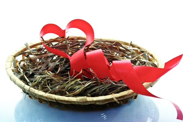 The red ribbon, the heart, love is in the basket of isolated on a white background — Stock Photo, Image