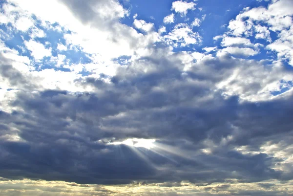 Los rayos del sol rompiendo las nubes oscuras de la lluvia — Foto de Stock