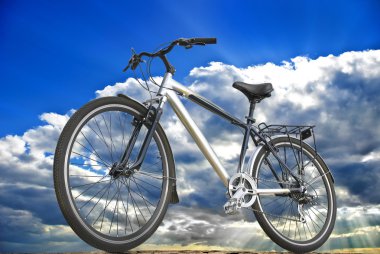 Spor motor arka planda gökyüzü, bulutlar ve güneş ışığı.