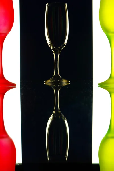 Transparent and the red-green wine glasses on the black-and-white background with reflection — Stock Photo, Image