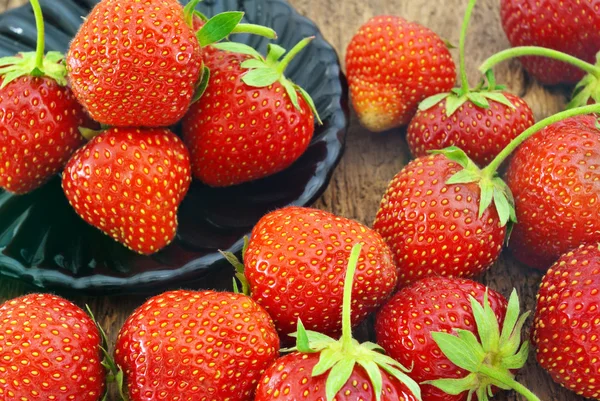 Mogna röda jordgubbar på en trä bakgrund. — Stockfoto