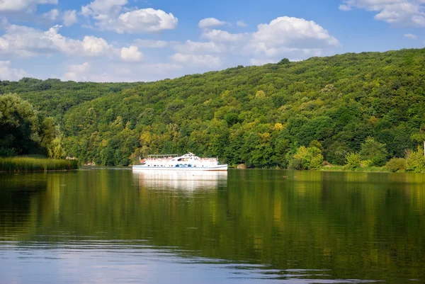 Barca bianca galleggiante lungo il fiume su uno sfondo di foresta . — Foto Stock