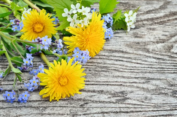 Dandelion and forget-me on a wooden background — Stock Photo, Image