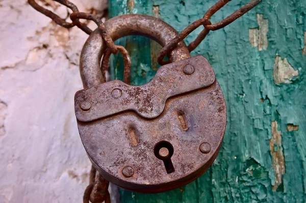 En la vieja puerta de madera, instalado un candado oxidado —  Fotos de Stock