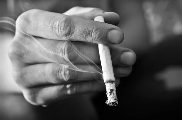 Hand roker houden een verlichte, roken van een sigaret — Stockfoto