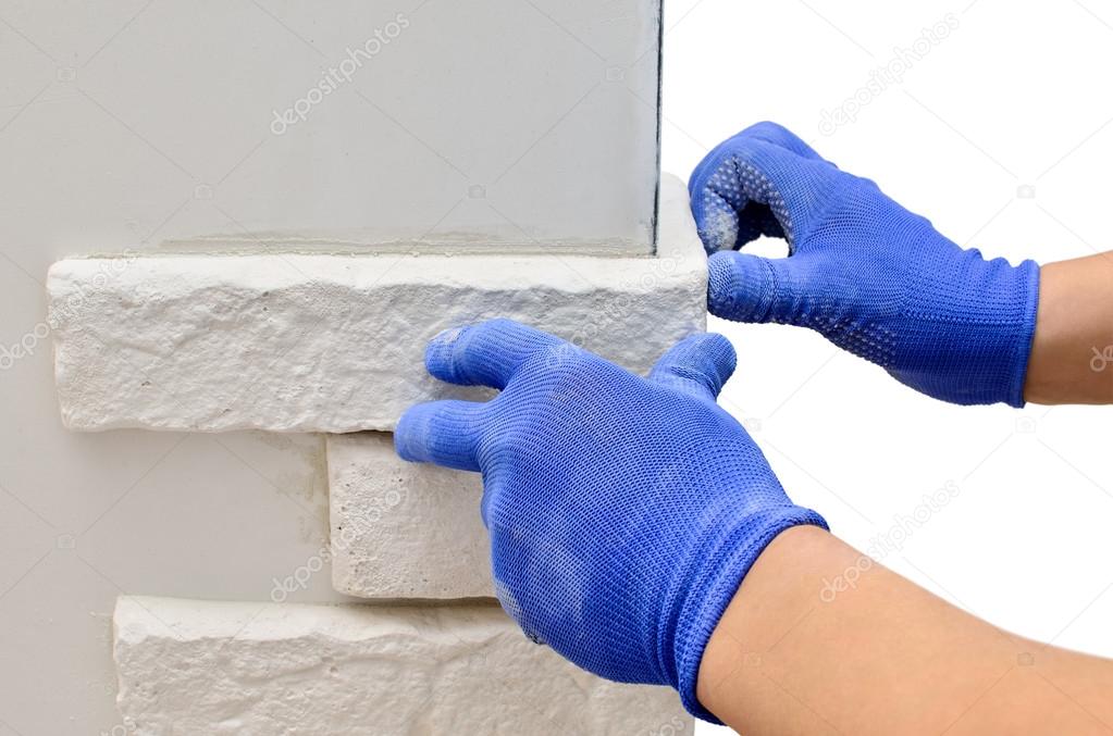 Facing wall decorative tiles, workers in blue glove