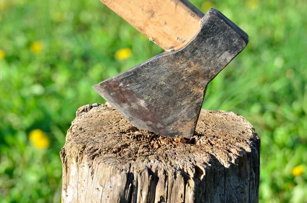 Vieille hache rouillée coincée dans une bûche de bois sèche — Photo