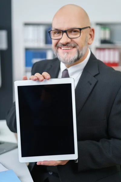Зрелый бизнесмен держит планшетный компьютер — стоковое фото