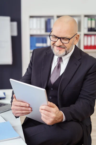 Zakenman zittend lezen op zijn Tablet-PC — Stockfoto