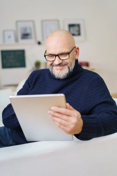 Attractive middle-aged man relaxing with a tablet — ストック写真