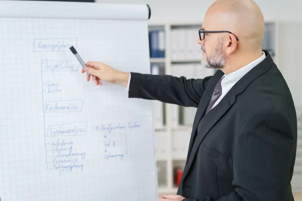 Maturo uomo d'affari spiegando un grafico — Foto Stock