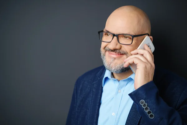 Sorridente uomo maturo che parla sul cellulare in studio — Foto Stock