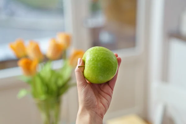 Mujer sosteniendo una granja de manzana verde fresca — Foto de Stock