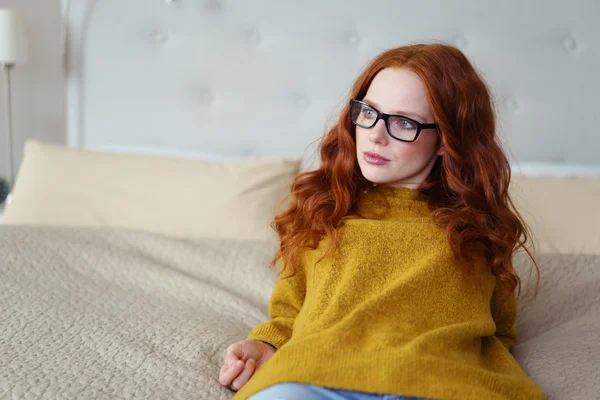 Pretty woman wearing glasses relaxing on her bed — Stock Photo, Image