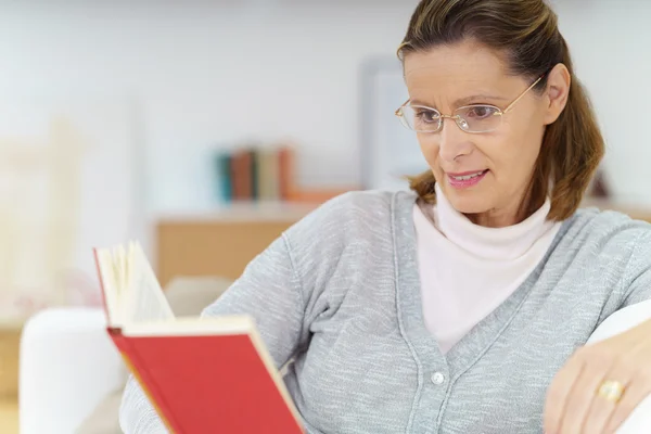 Middle-aged lady relaxing with a book — Stock Photo, Image