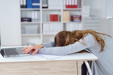Woman asleep at desk in office clipart