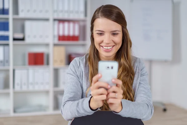 Lachende Frau macht Selfie in kleinem Büro — Stockfoto