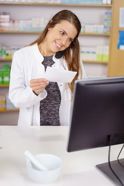 Pharmacist at counter talking on phone — Stock Photo, Image