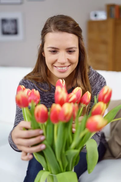 Pretty young woman arranging a vase of flowers — Stock Photo, Image
