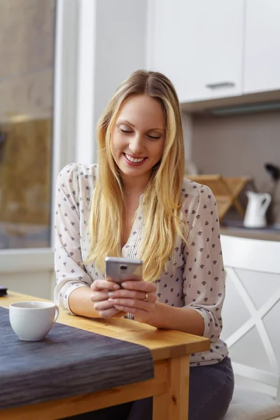 Attraktive blonde Frau liest ihre SMS — Stockfoto