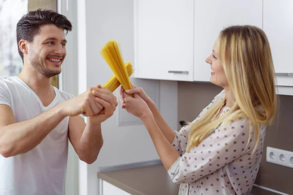 Man och kvinna spelar slåss med pasta — Stockfoto