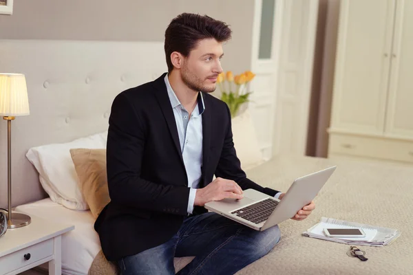Pensativo homem de negócios elegante usando um laptop — Fotografia de Stock