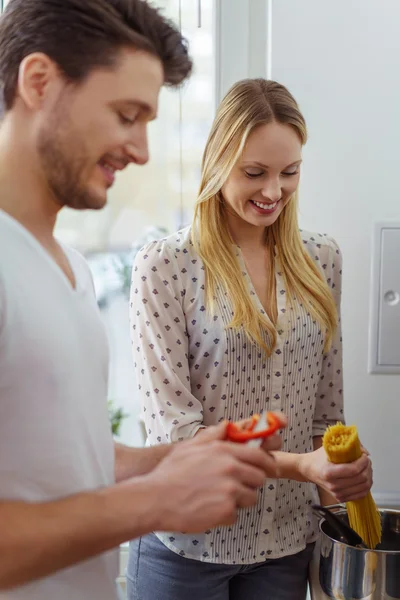 Молода дружина готує макарони з чоловіком на кухні — стокове фото
