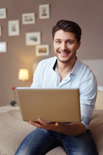 Empresário atraente trabalhando em um laptop em casa — Fotografia de Stock