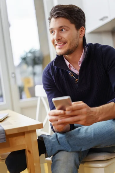 Attractive man thinking about a text message — Stock Photo, Image
