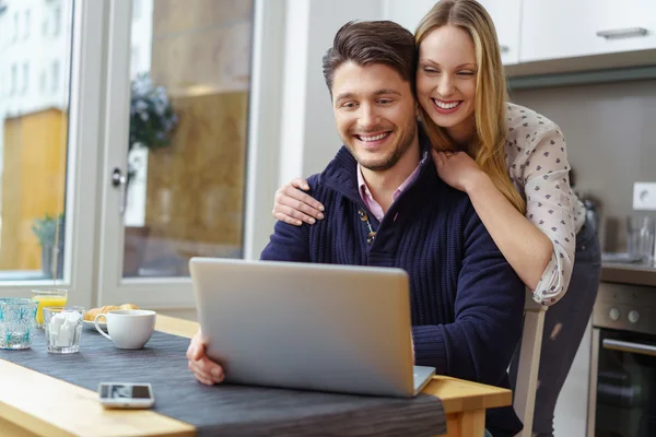 Happy woman leaning on smiling man using laptop — Stock Photo, Image