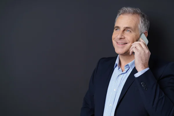 Homem de negócios feliz conversando em seu telefone celular — Fotografia de Stock