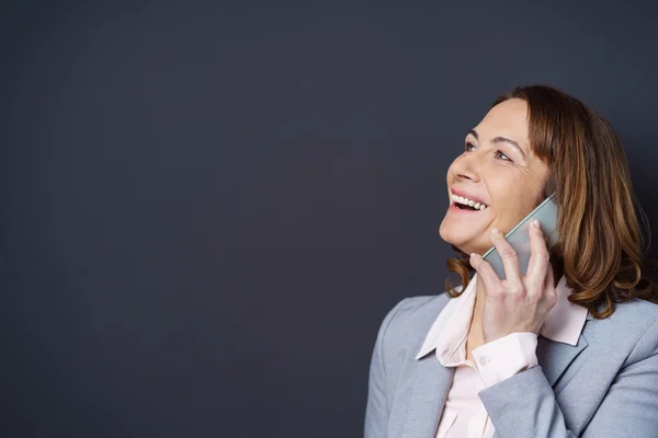 Žena se směje, když se chtě na mobilu — Stock fotografie