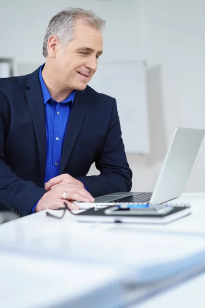 Aantrekkelijke zakenman het lezen van zijn laptop scherm — Stockfoto