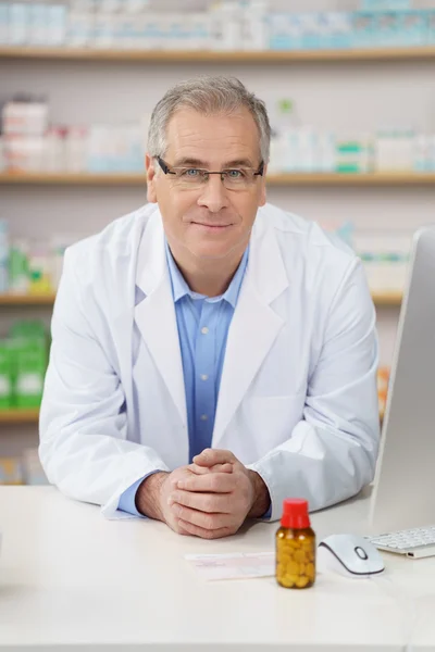 Male pharmacist leaning on the counter — Stock Photo, Image