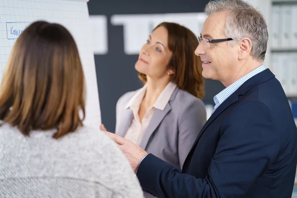 Drie zakenmensen die de grafiek bespreken — Stockfoto