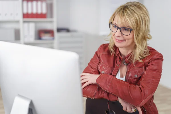 Businesswoman reading information on her desktop — Stock Photo, Image