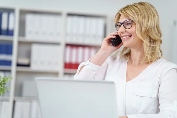 Attraktive blonde Geschäftsfrau, die einen Anruf entgegennimmt — Stockfoto